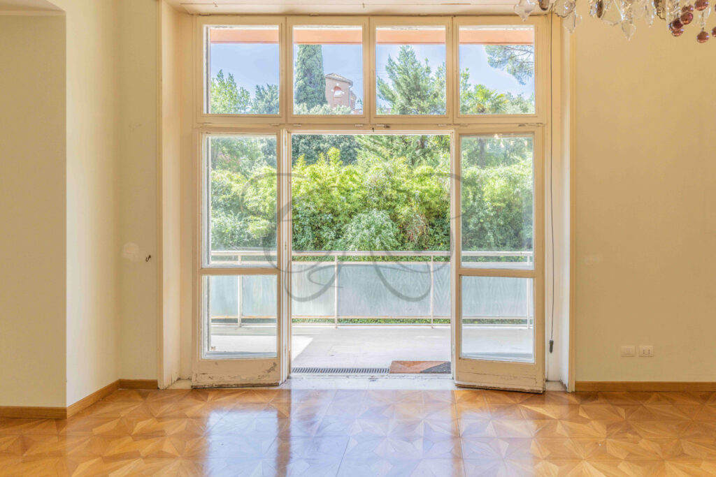 Ampia finestra di una camera da letto con vista sul verde del terrazzo privato, immobile di lusso in vendita a Roma Parioli.