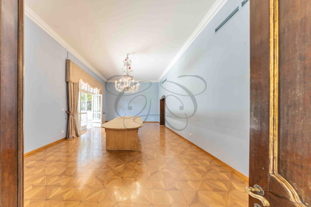 Vista in profondità del salone di rappresentanza che mostra la successione degli ambienti in un appartamento di lusso a Roma Parioli.