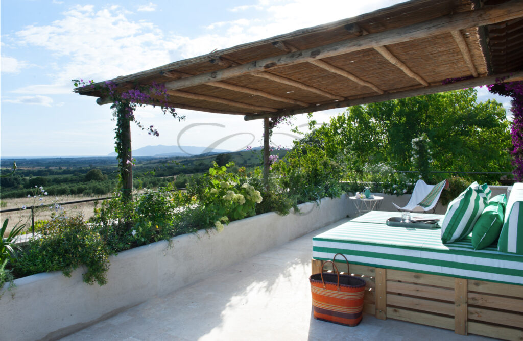 The outdoor lounge area under a vine-covered pergola at the Tuscan villa for rent by Class & Country Homes.