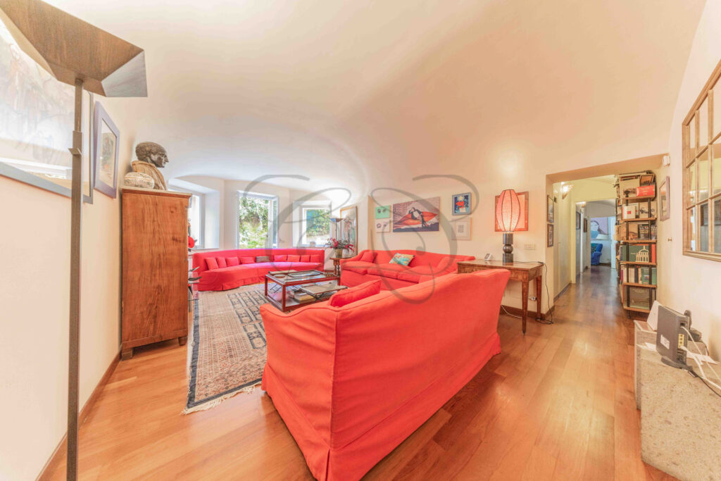 Main living room with red sofas and antique wooden cabinet - Class & Country Homes.