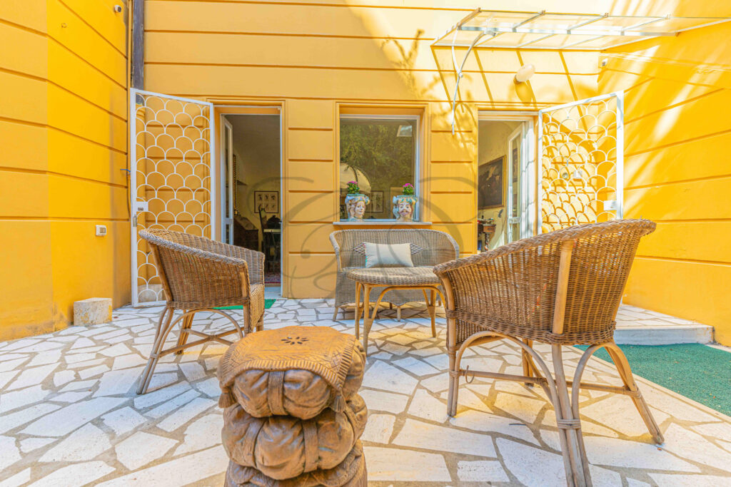 Wicker chairs and seating on the private stone patio - Class & Country Homes.