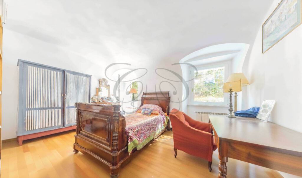 Second bedroom with antique wooden sleigh bed and vaulted ceiling - Class & Country Homes.