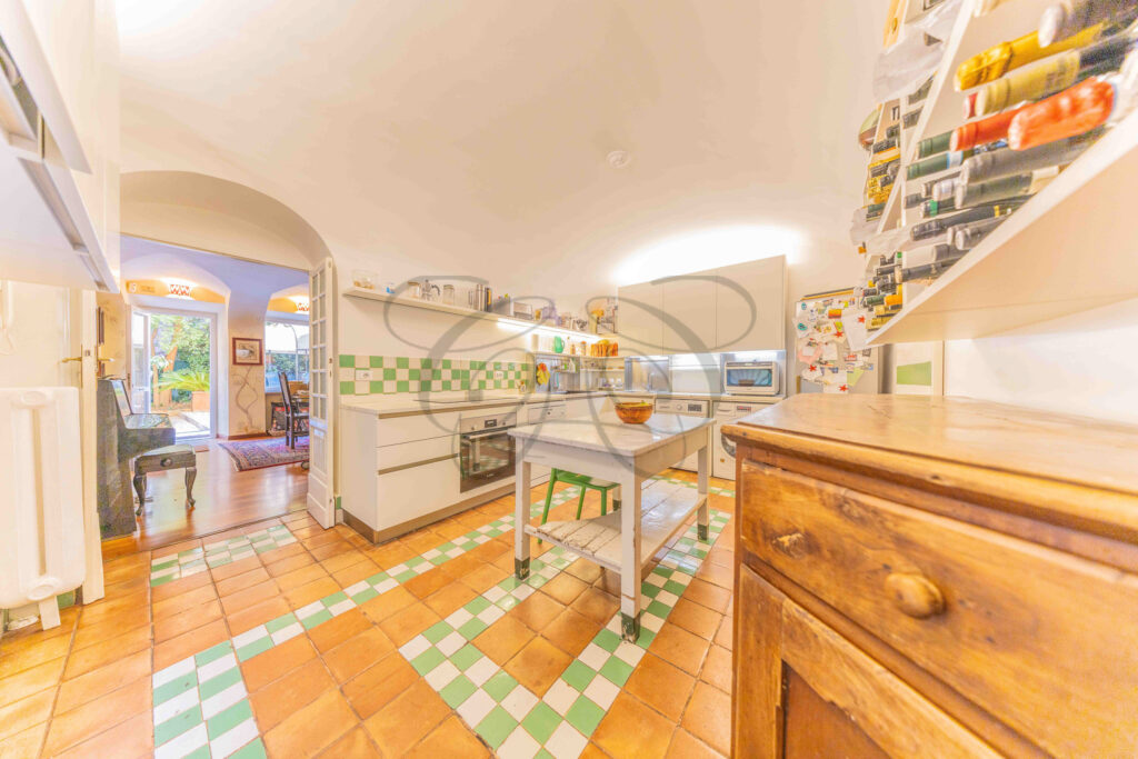 Large kitchen with terracotta and green tiled floor - Class & Country Homes.