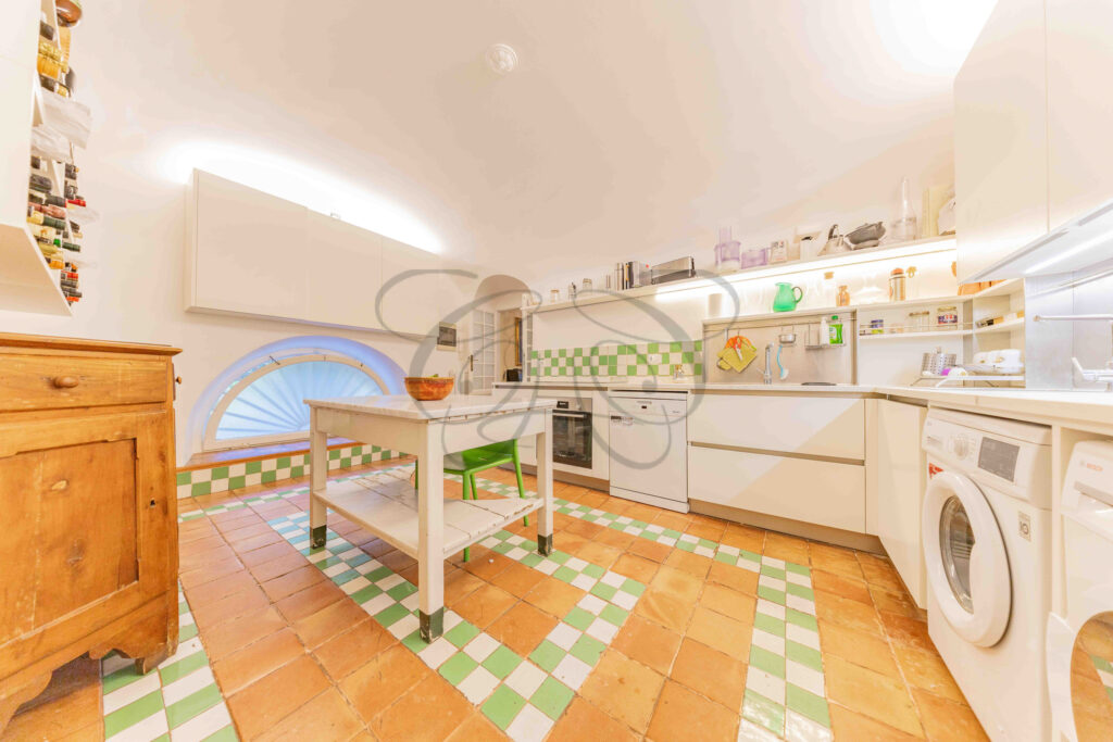 Kitchen with white cabinetry and central island table - Class & Country Homes.