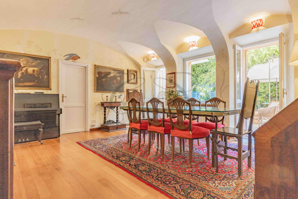Elegant dining room with vaulted ceilings and red chairs - Class & Country Homes.