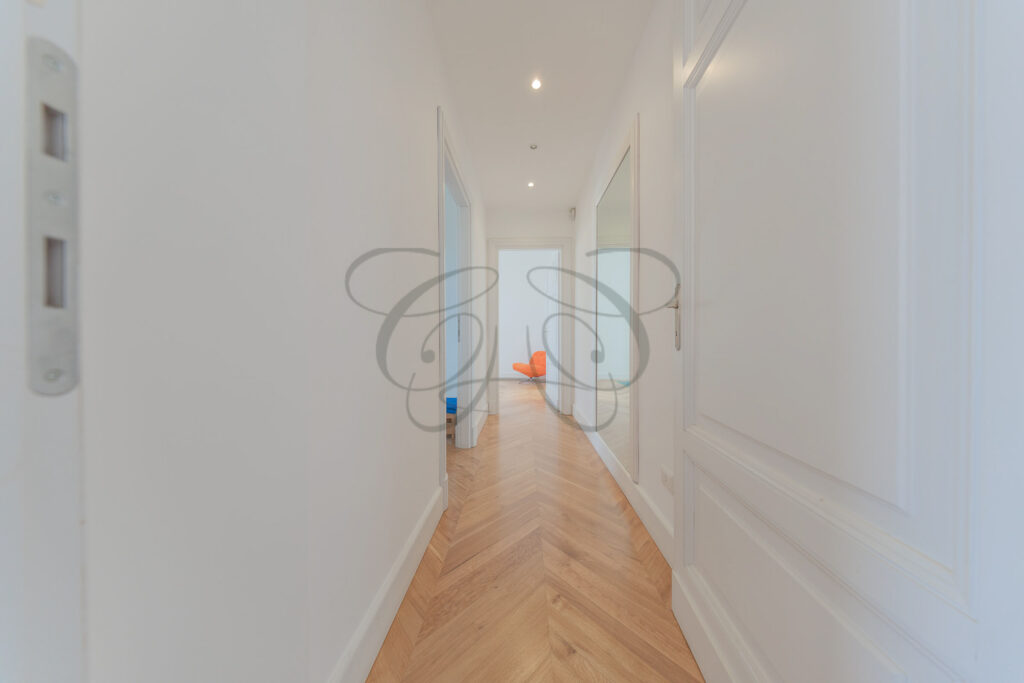 Hallway with parquet flooring leading to the spiral staircase - Class & Country Homes.