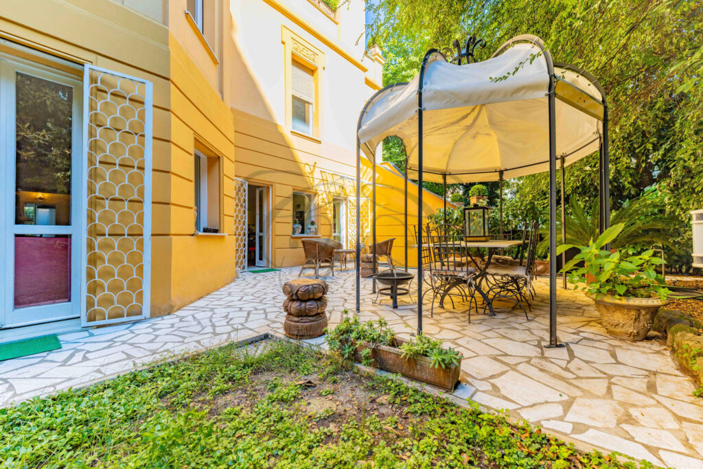 View of the private garden, stone patio, and villino exterior - Class & Country Homes.