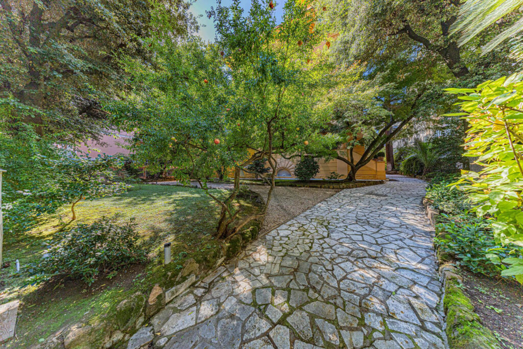 Lush greenery surrounding the stone path in the private garden - Class & Country Homes.