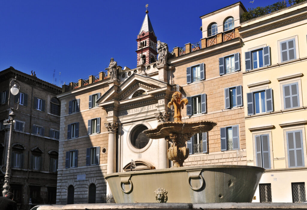 Side view of the fountain and church in Piazza Farnese - Class & Country Homes.
