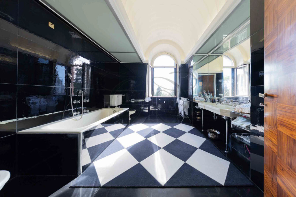 The 1930s-style master bathroom with checkered floor and bathtub - Class & Country Homes.
