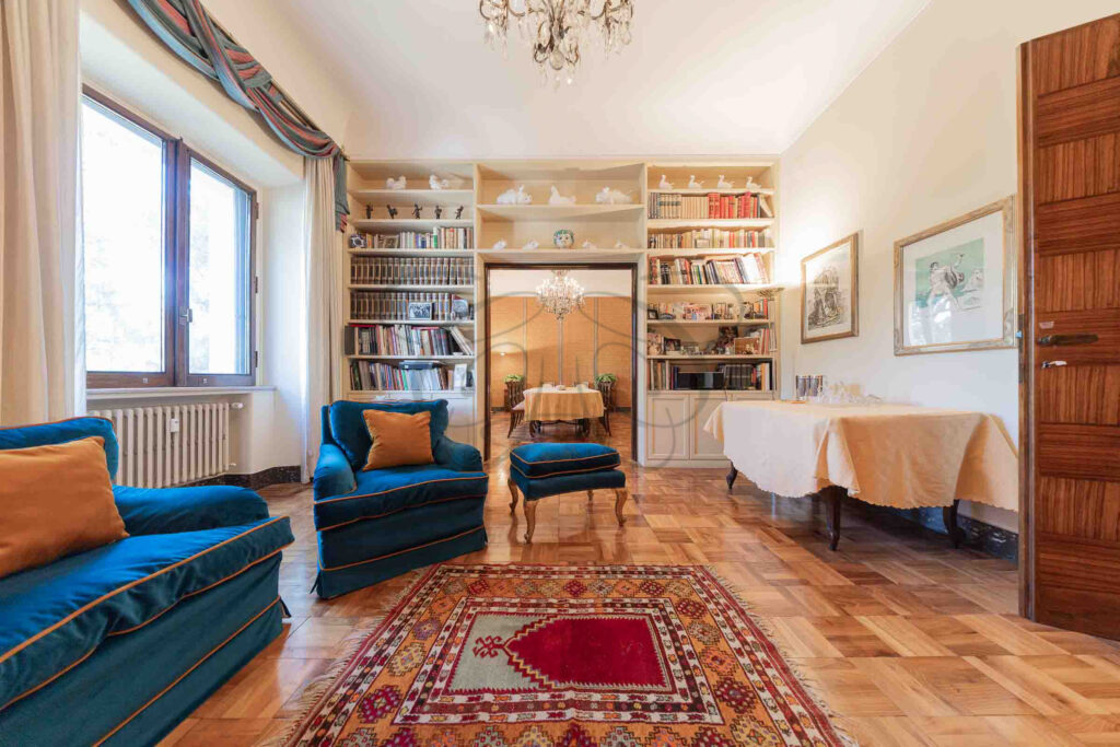 A library room with blue sofas and wall-to-wall bookshelves - Class & Country Homes.