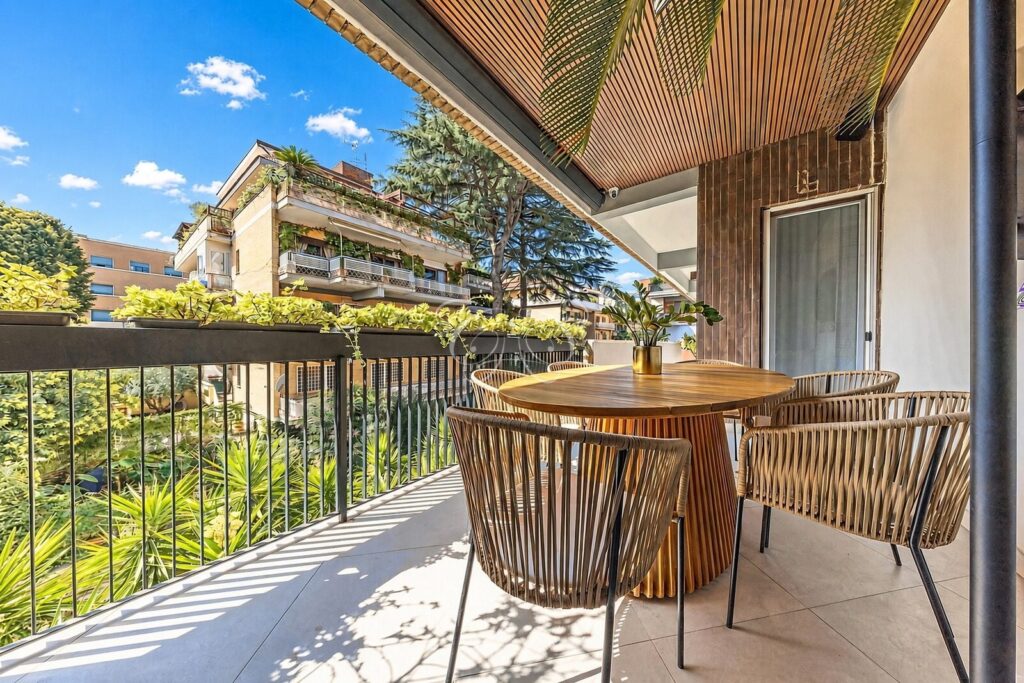 Camilluccia Roma appartamento vendita lusso — terrazzo con tavolo da pranzo in teak affacciato sul verde