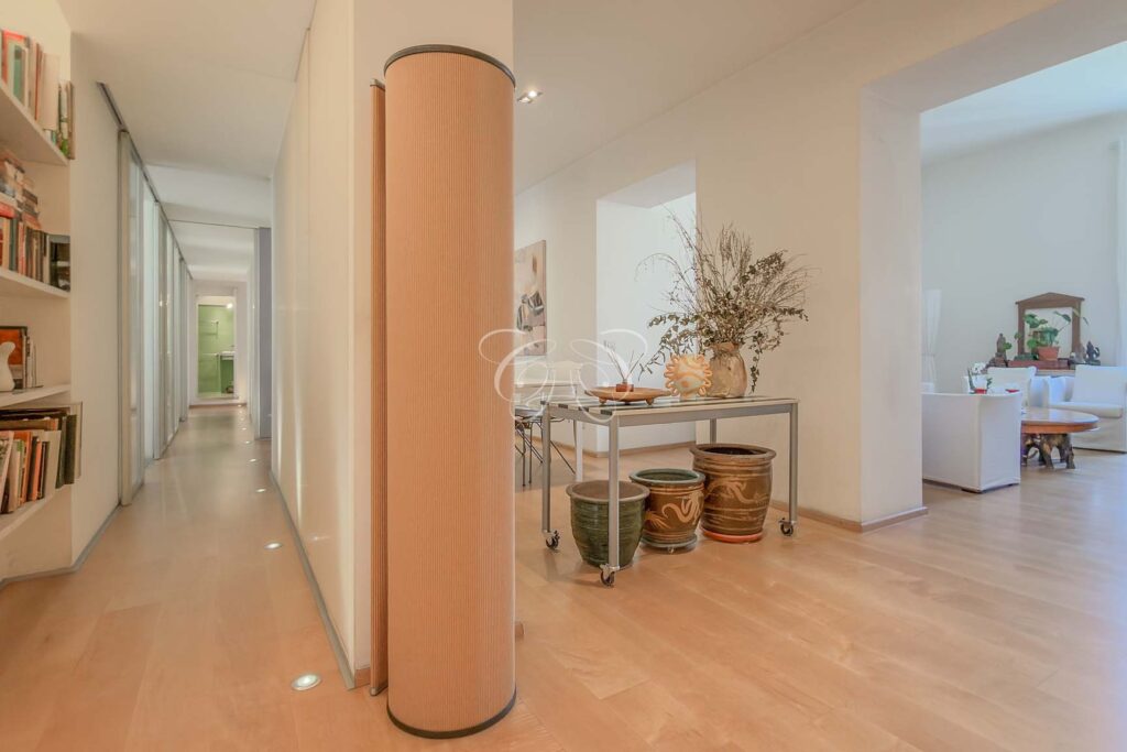 Sell luxury apartment Prati Rome — L-shaped hallway with built-in bookcases